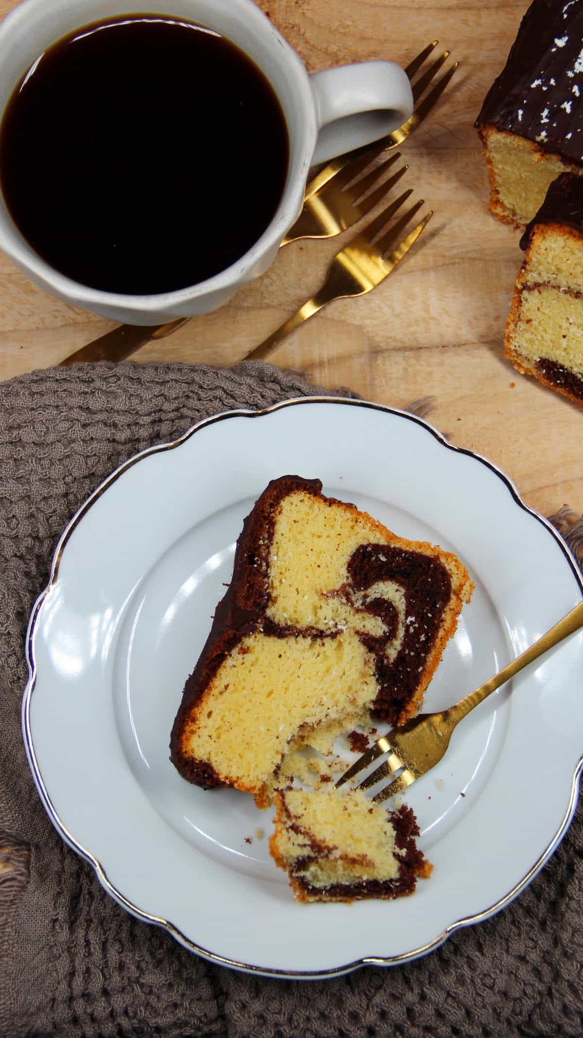 Marmorkuchen, Kuchenstück auf einem weißen Teller neben einer Tasse Kaffee
