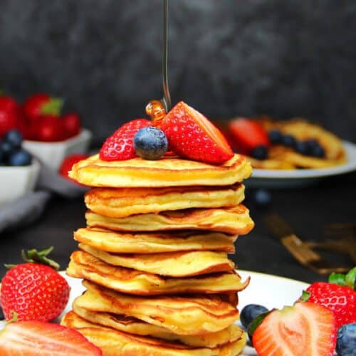 Pancakes gestapelt mit Beeren und Ahornsirup dekoriert