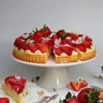Erdbeerkuchen mit Puddingcreme, Kuchen auf weißem Tortenständer mit vielen Erdbeeren dekoriert