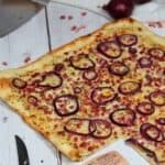 Flammkuchen auf einem weißen Holztisch