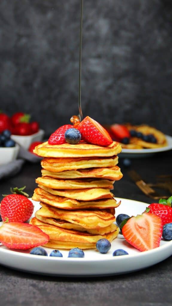 Pancakes auf einem Teller gestapelt, mit Beeren verziert