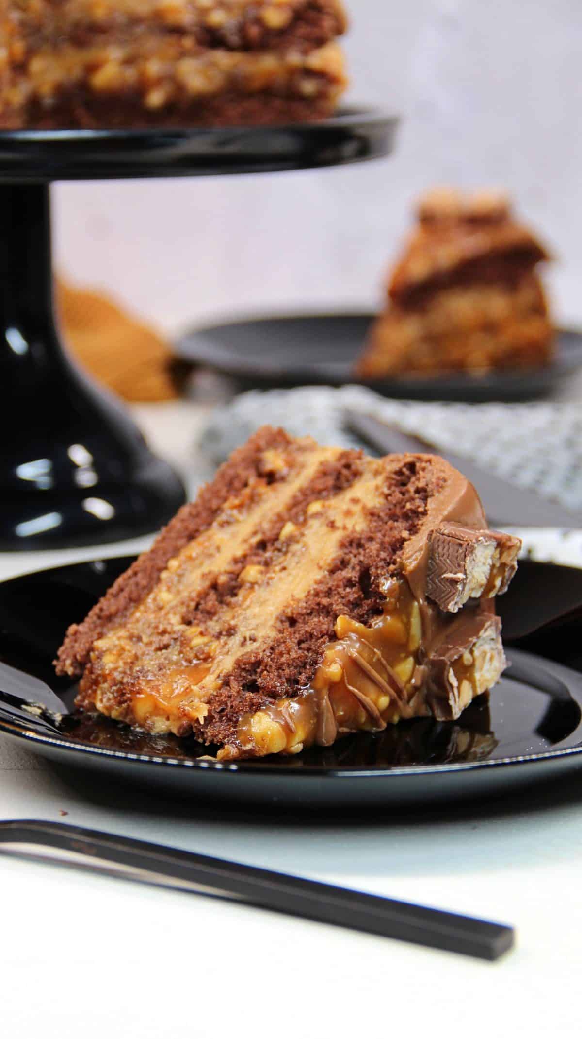 Snickers-Torte, Tortenstück auf einem schwarzen Teller