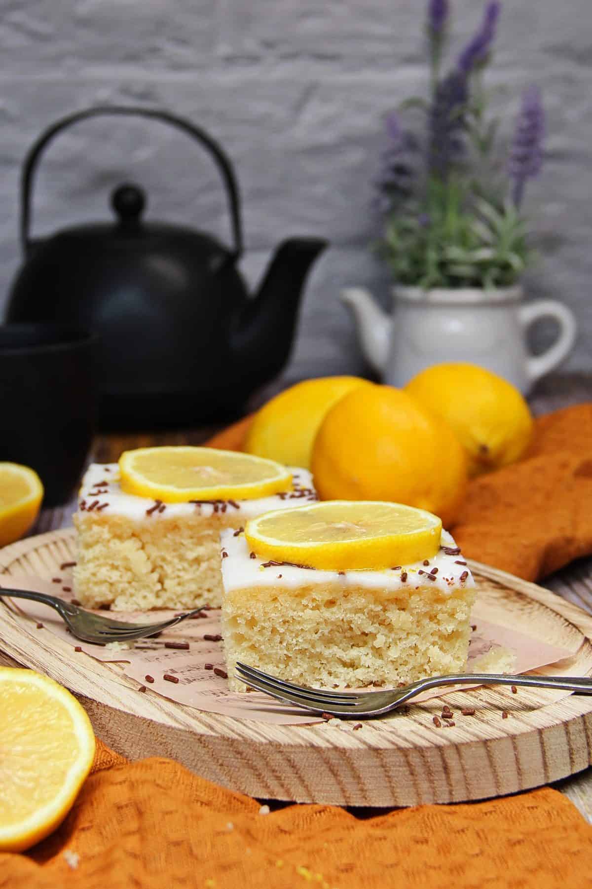 2 Stücke Zitronenkuchen auf einem Holztablett präsentiert