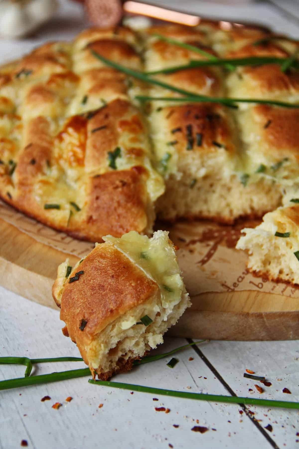 Knoblauch-Mozzarella-Zupfbrot, ein Brotstück abgezupft