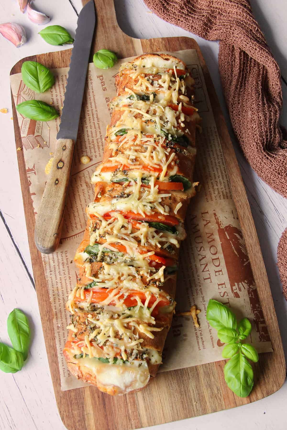 Fächer-Baguette mit Tomate-Mozzarella auf einem Servierbrett aus Holz