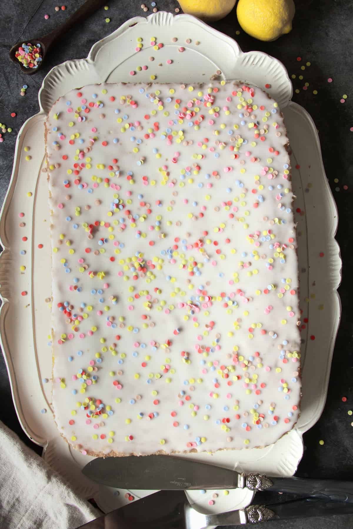 Konfetti-Kuchen vom Blech, auf einer großen, weißen, verschnörkelten Kuchenplatte