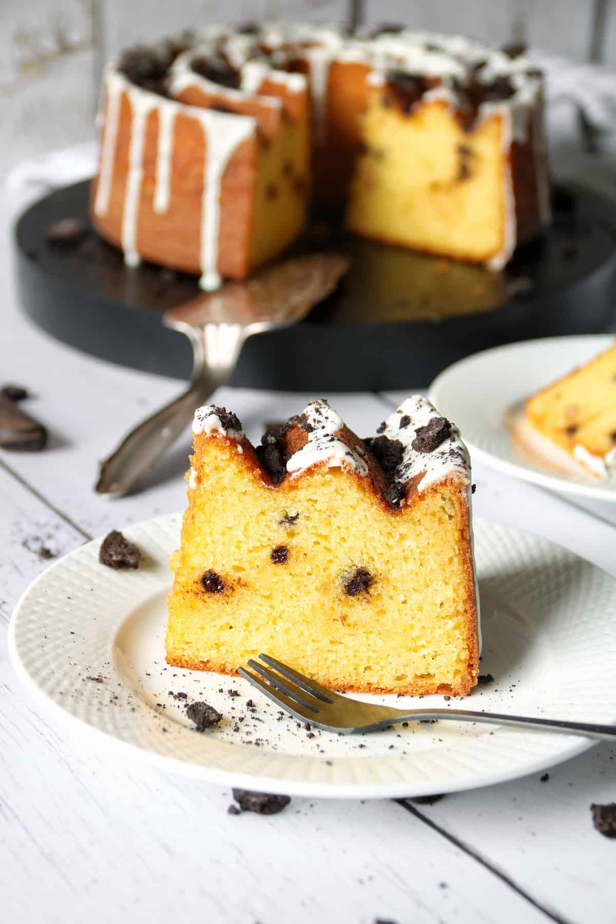 Paradiescreme Kuchen Cookies & Creme mit weißer Schokolade und Oreostückchen. Kuchenstück auf einem weißen Teller