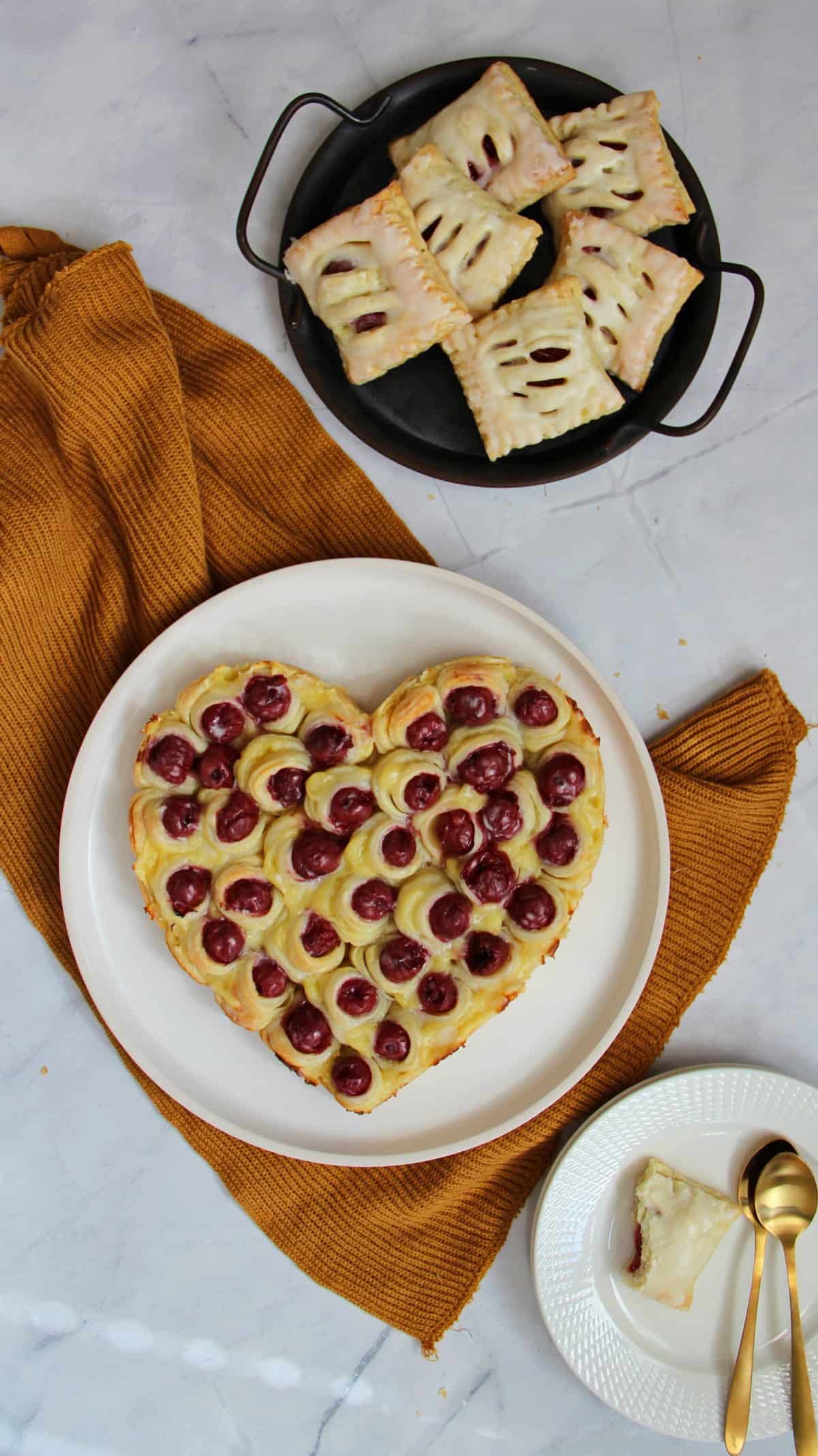 Blätterteig-Herz mit Kirschen und Pudding auf einem weißen Teller