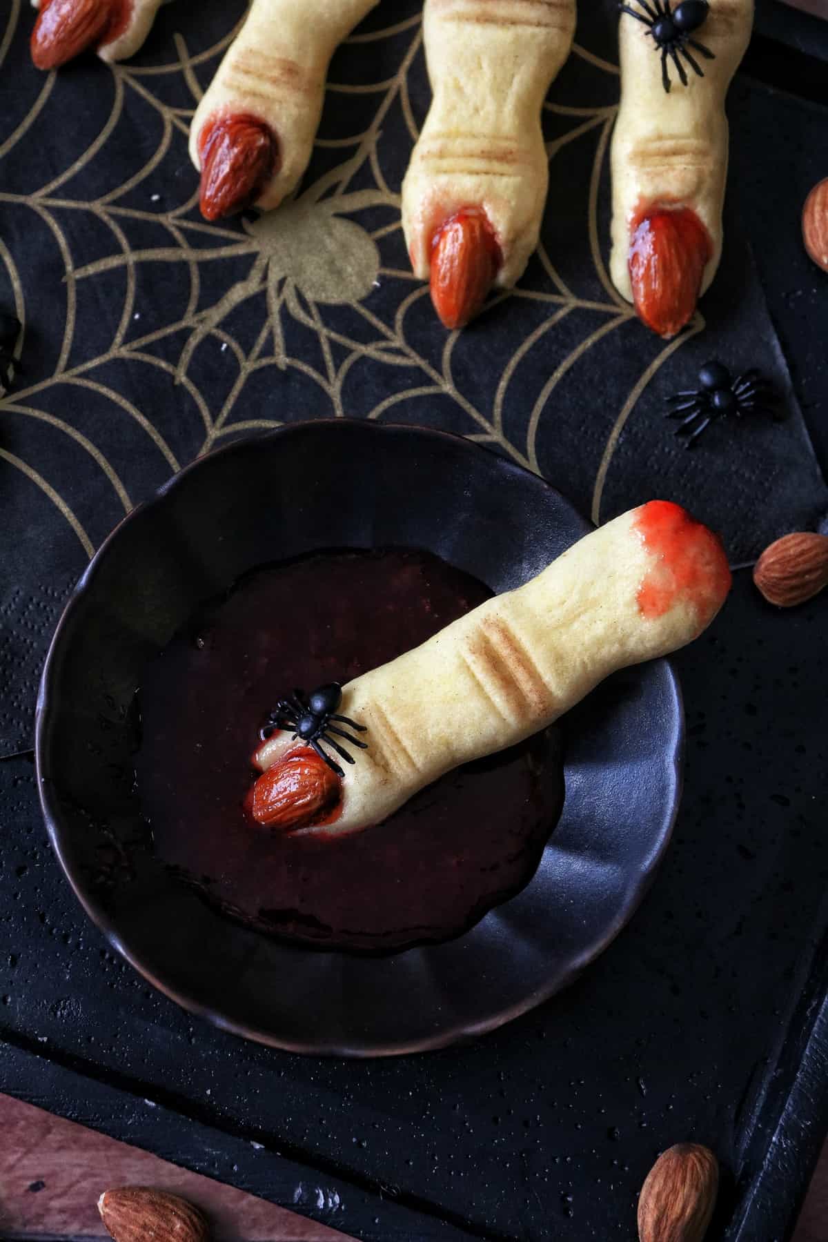 Hexenfinger-Keks in einer schwarzen Schale mit Erdbeermarmelade