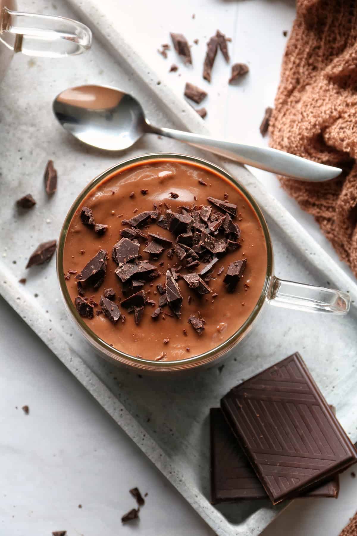 Schokoladenpudding im Thermomix® in einem Glas von oben fotografiert. Mit Schokostücken verziert