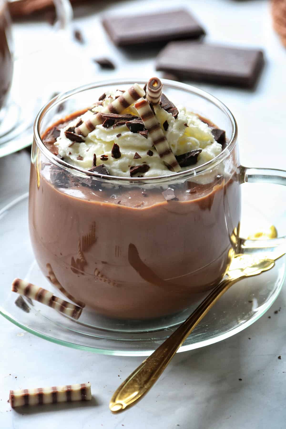 Schokoladenpudding im Thermomix® in einem Glas, mit Sahne, Zebraröllchen und Schokoraspeln dekoriert