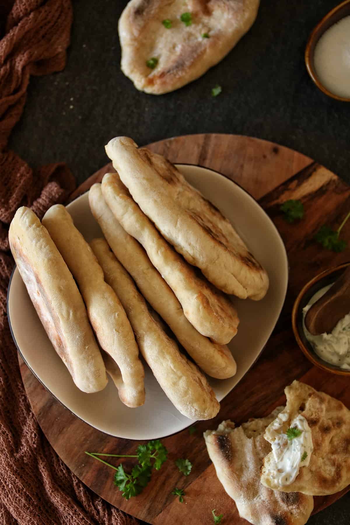 Pfannenbrot ohne Hefe (indisches Naan-Brot), in einem Teller auf einem Holztablett 