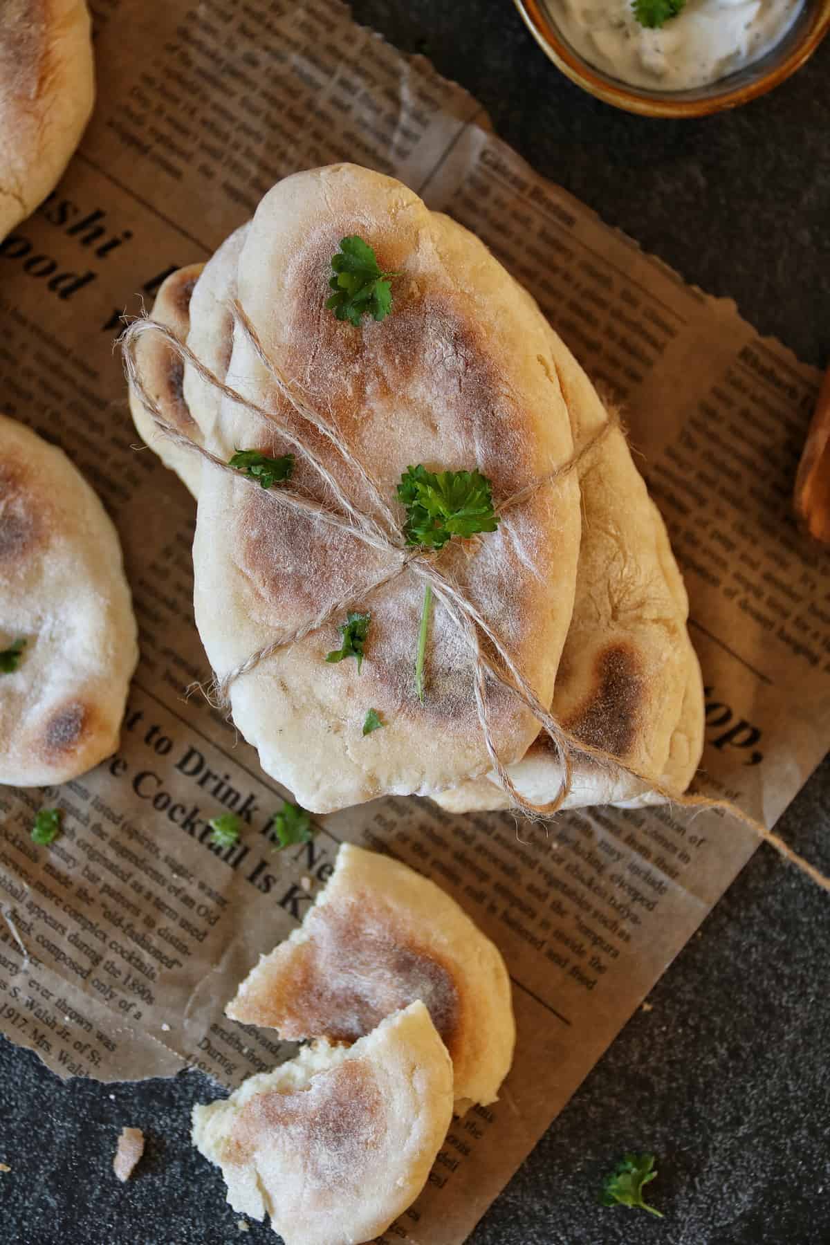 Pfannenbrot ohne Hefe (indisches Naan-Brot), gestapelt und mit einem Band zusammengebunden. Garniert mit frischer Petersilie.