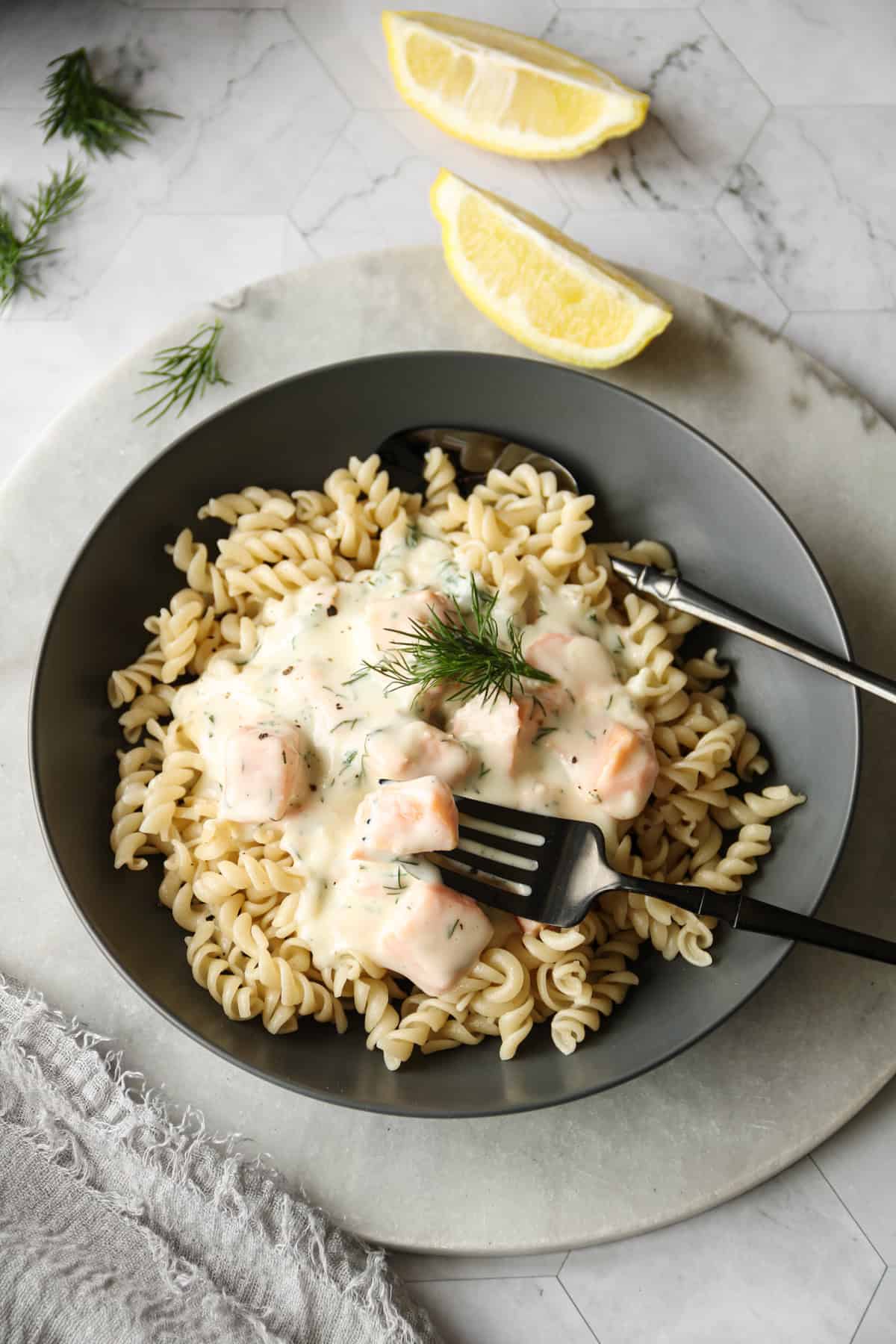 Cremige Sahnesoße mit Lachs in einem schwarzen Teller mit Nudeln