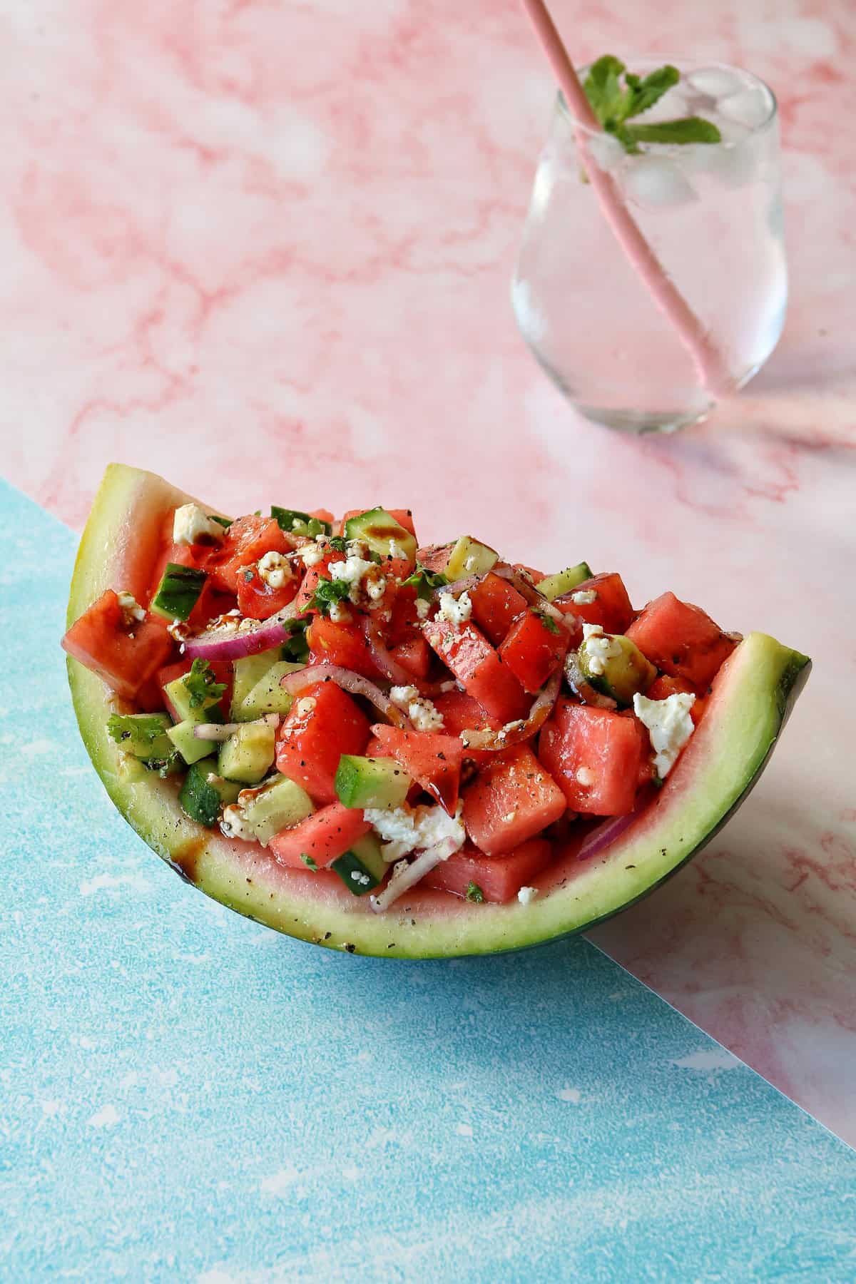 Wassermelonen-Feta Salat in einem ausgehöhlten Wassermelonen-Viertel angerichtet