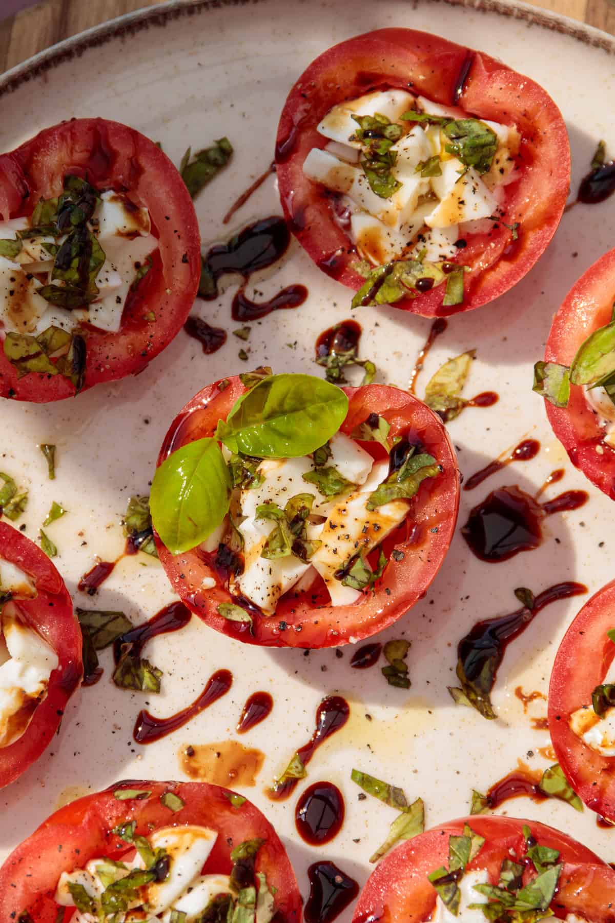 Teller mit Tomaten-Mozzarella Salat aus der Vogelperspektive fotografiert.