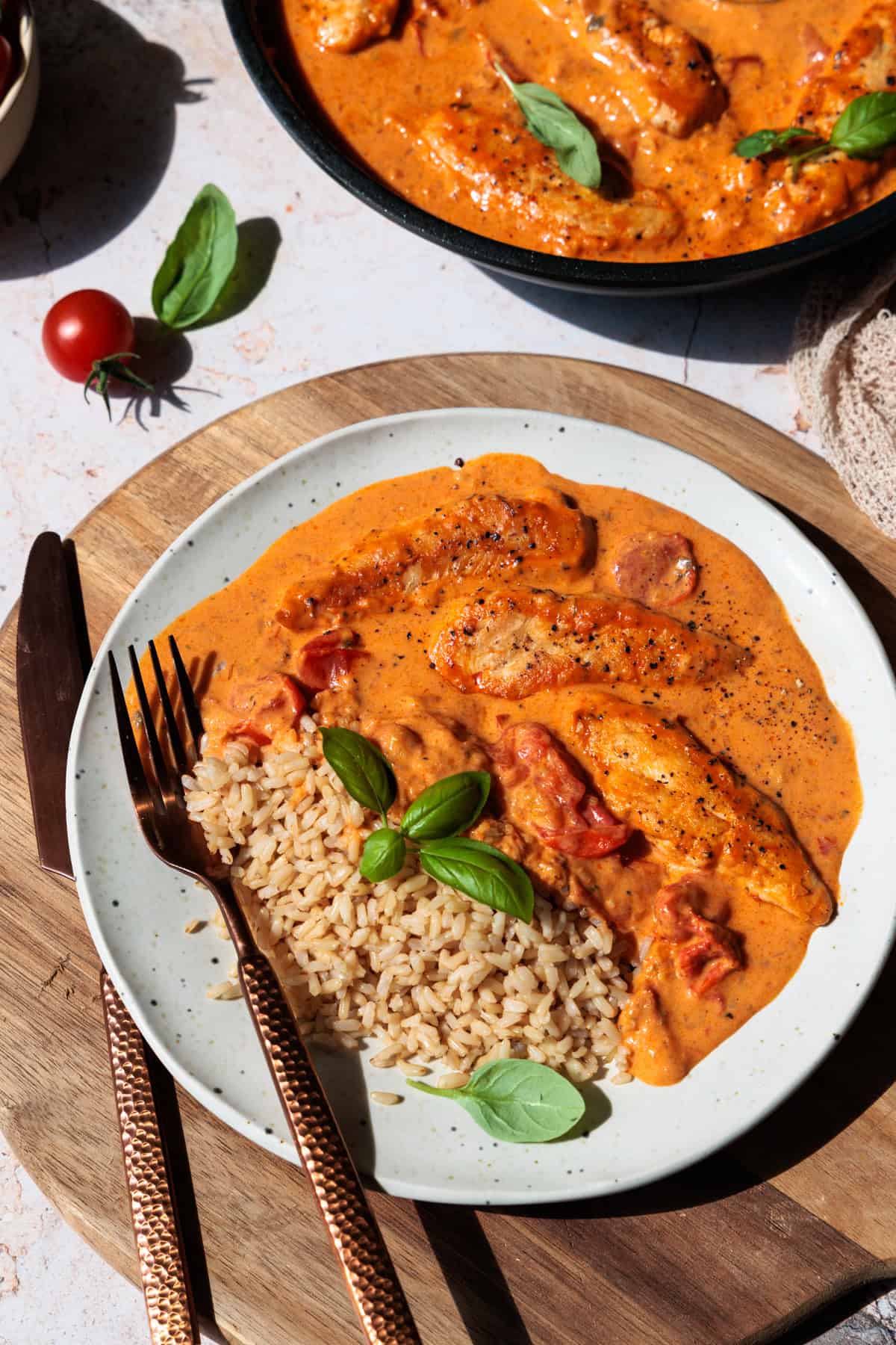 Hähnchenfilet in Frischkäse-Parmesan-Soße auf einem Teller mit Naturreis