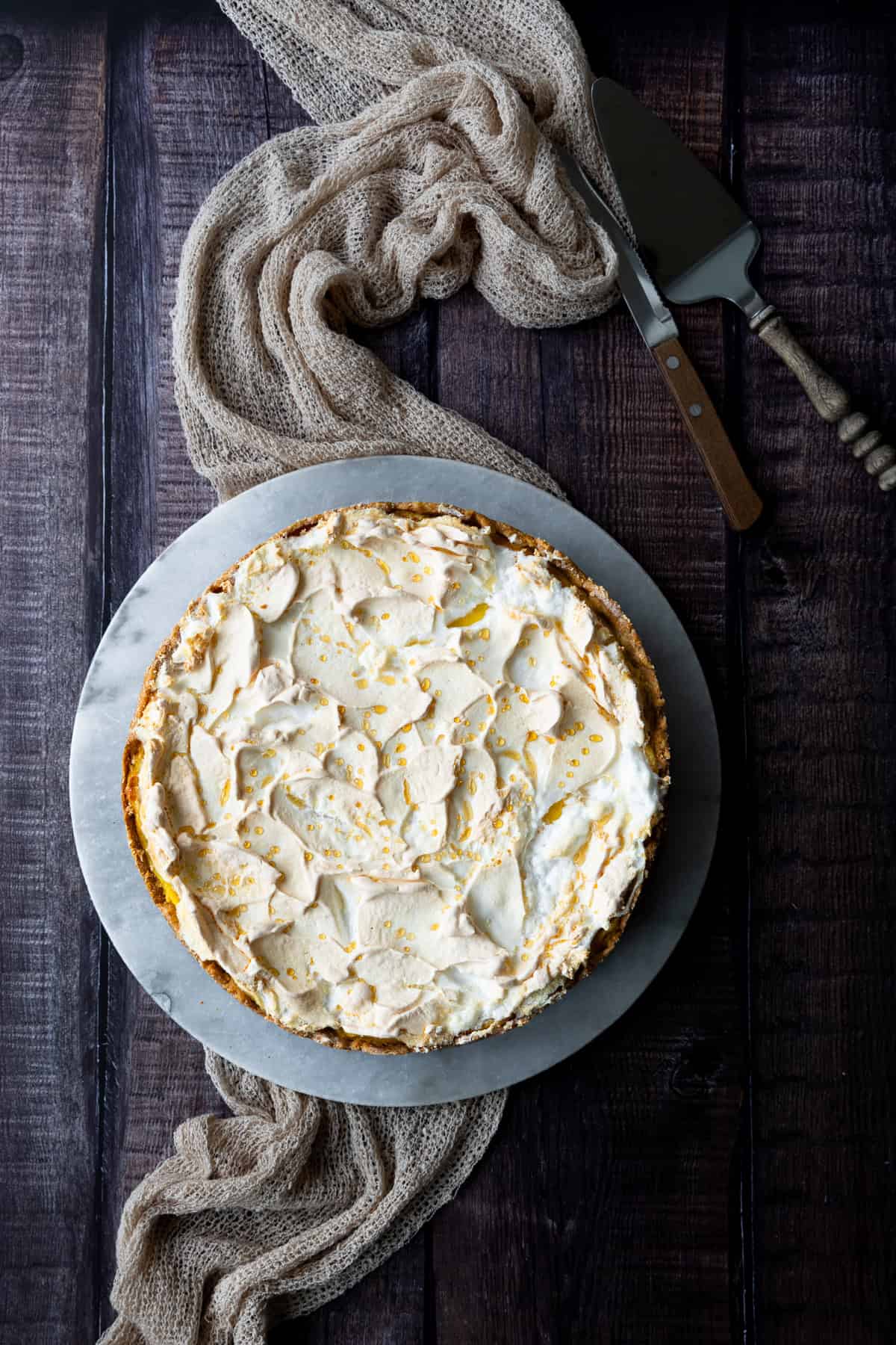 Käsekuchen mit Baiser - Tränchentorte als ganze Torte von oben fotografiert. Die Goldtröpfchen sind deutlich zu erkennen. 