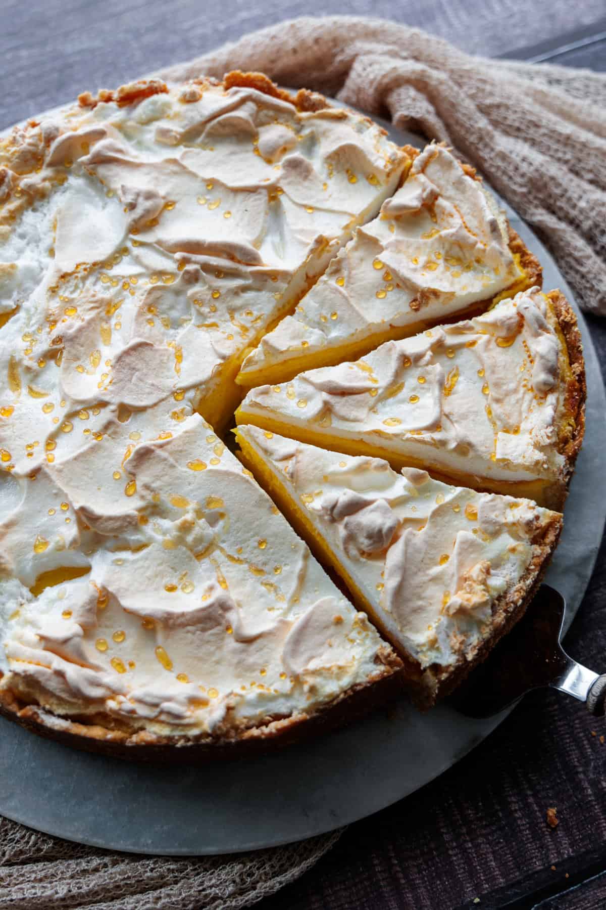 Käsekuchen mit Baiser - Tränchentorte auf einer Marmorplatte, 3 Stücke sind geschnitten