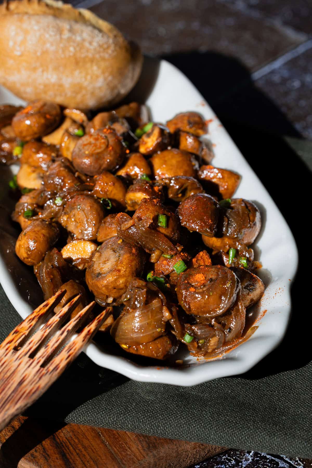 Champignons in Knoblauchsoße in einer Pommes Schale aus Porzellan, mit Paprikapulver bestreut.