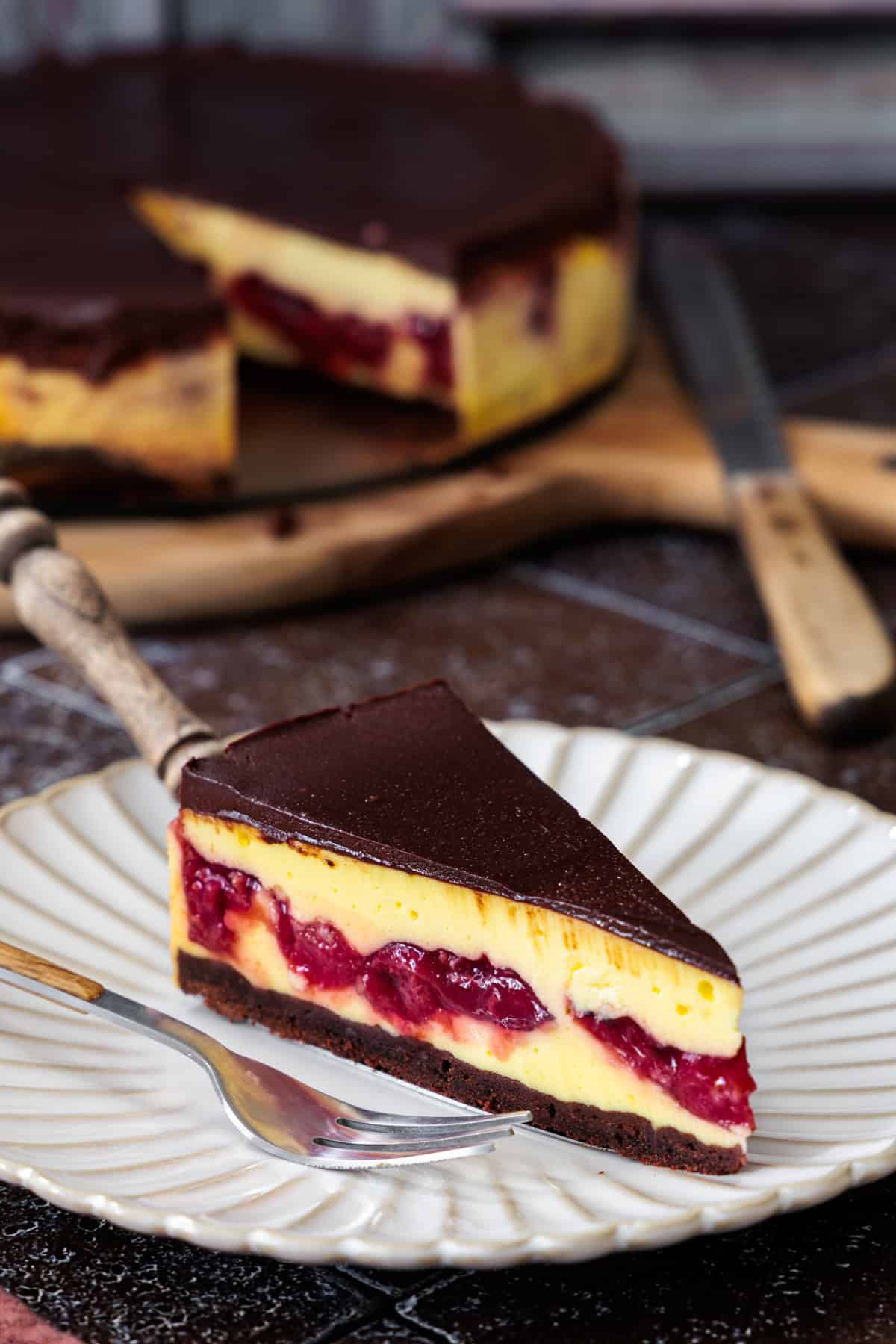 Schwarzwälder Käsetorte mit Kirschen und Schoko-Ganache auf einem wellenförmigen Teller