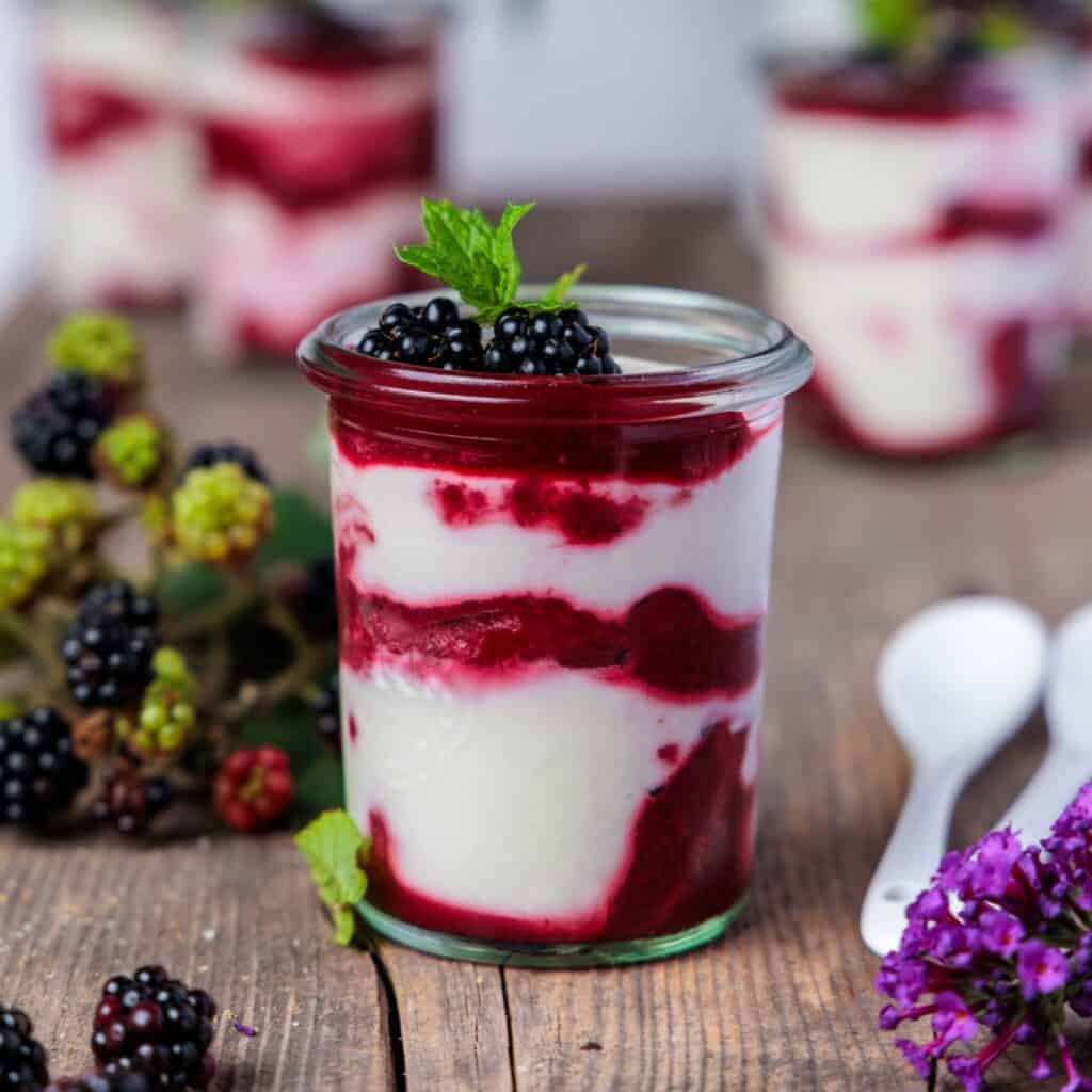Rezepte mit Brombeeren: Brombeer-Mascarpone-Dessert im Glas mit Brombeerpüree-Swirl, frischen Brombeeren und Minze.