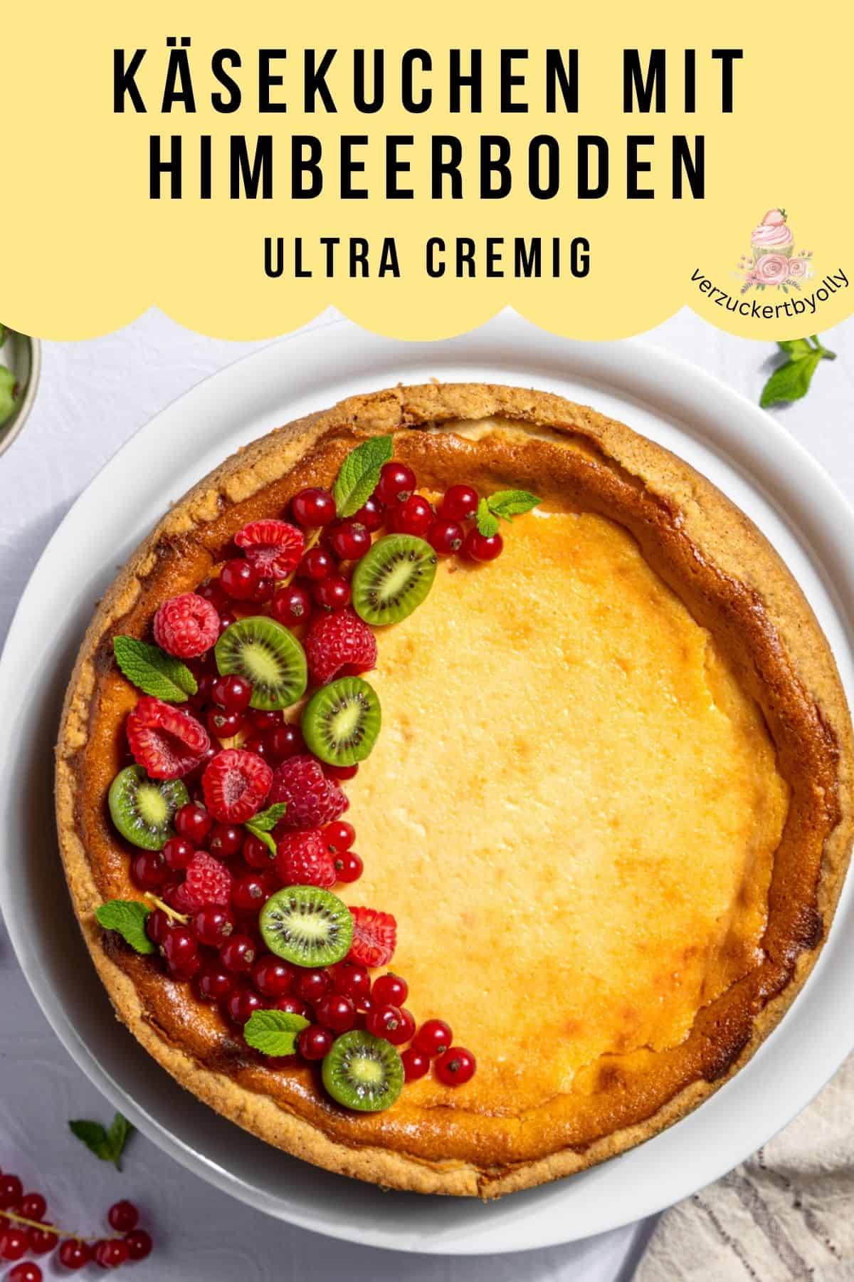 Pin für Pinterest: Ein von oben fotografierter Käsekuchen mit Himbeerboden. Er hat einen hohen Rand, eine goldbraun gebackene Oberfläche und ist halbseitig mit frischen Himbeeren, roten Johannisbeeren, Mini-Kiwi-Beeren und Minze dekoriert. Das Bild ist eine Grafik mit dem Titel Käsekuchen mit Himbeerboden ultra cremig und dem Logo verzuckertbyolly.