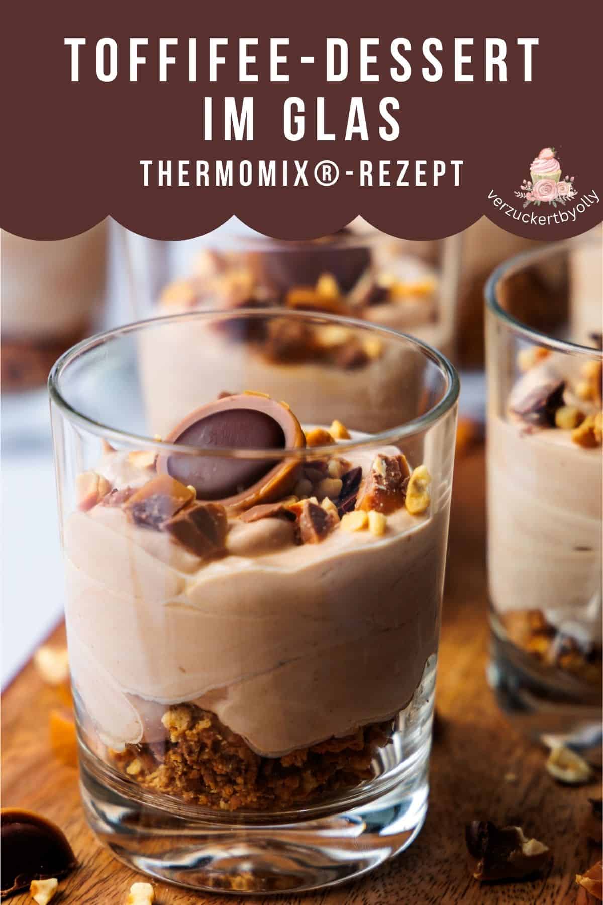 Grafik für Pinterest: Thermomix®-Rezept mit dem Titel "Toffifee-Dessert im Glas". Das Bild zeigt ein Schichtdessert in mehreren Gläsern, bestehend aus Toffifee-Creme und einem knusprigen Keksboden. Ein Glas im Vordergrund ist mit gehackten Haselnüssen und einem halbierten Toffifee garniert. Das Rezept stammt von "verzuckertbyolly".